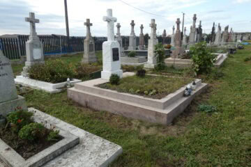 Вічний спочинок на Бучацькому цвинтарі, старі та нові могили з хрестами та квітами.