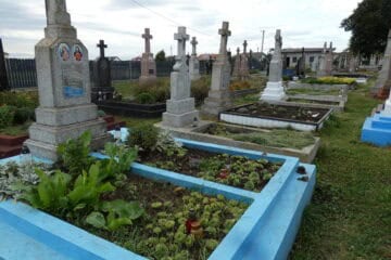 Могили на буцазакському цвинтарі з квітами та пам’ятниками.