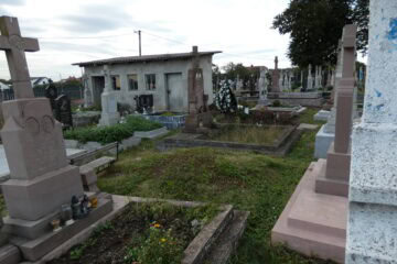 Різноманітні могили та пам'ятники на цвинтарі Бужач, історичний цвинтар, могили з квітами та свічками, символи пам'яті та вічності.