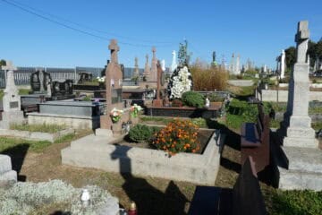 Вічна пам'ять у буцмацькому цвинтарі з квітами та пам’ятниками.