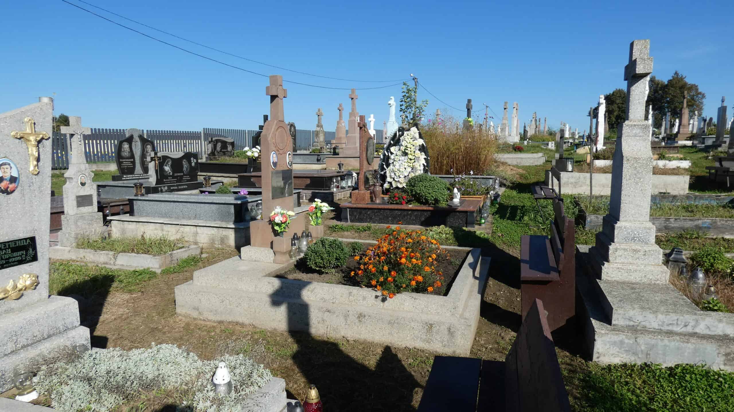 Вічна пам'ять у буцмацькому цвинтарі з квітами та пам’ятниками.