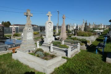 Вигляд цвинтаря в Буцачі з могилами та пам’ятниками під яскравим сонцем.