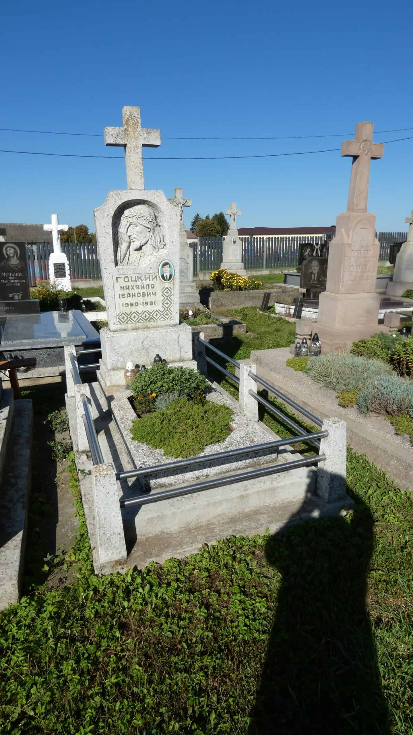 Могила з хрестом у цвинтарі Буцач, святковий і доглянутий пам'ятник.