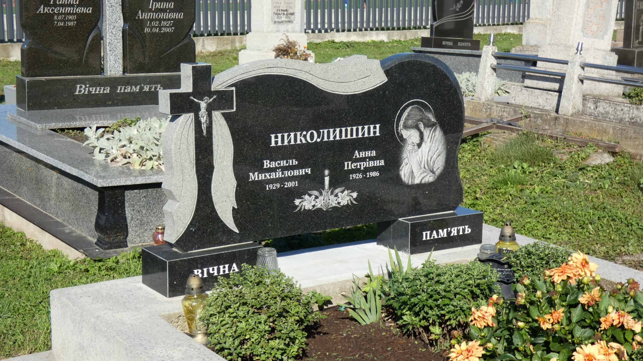 Меморіальний пам'ятник на кладовищі Буцач, гранітний надгробок з зображенням Ісуса та іменами похованих.