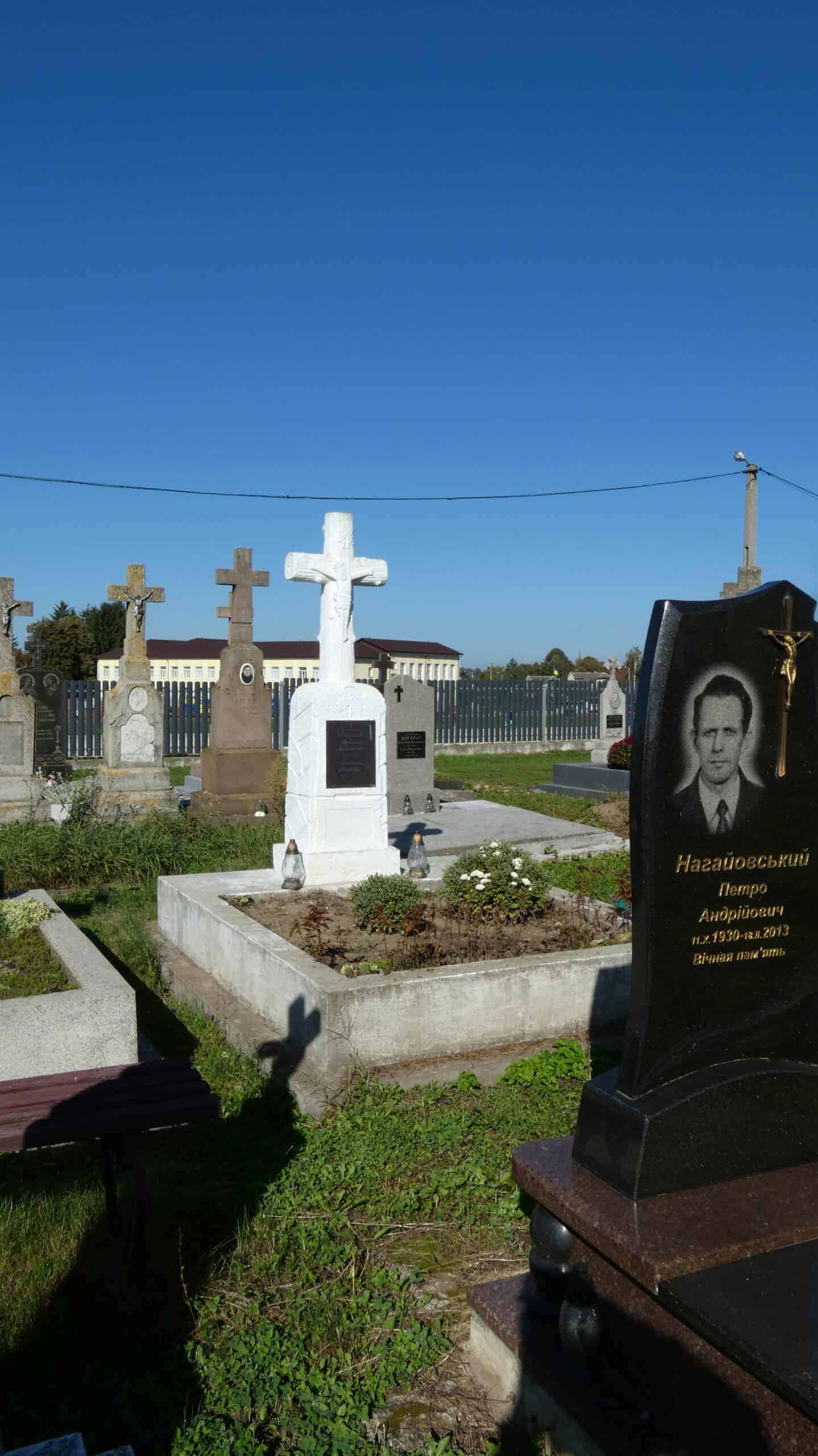 Високоякісне фотографічне зображення цвинтаря з пам’ятниками та хрестами в сонячний день.