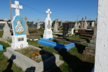 Могили на цвинтарі в Буцачі, покриті квітами та символічними пам’ятниками.