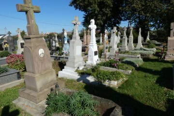 Могили в цвинтарі Буцач, історичне кладовище з пам’ятниками та квітами.