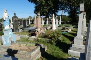 Вигляд українського цвинтаря з хрестами та меморіальними пам'ятниками у сонячний день.