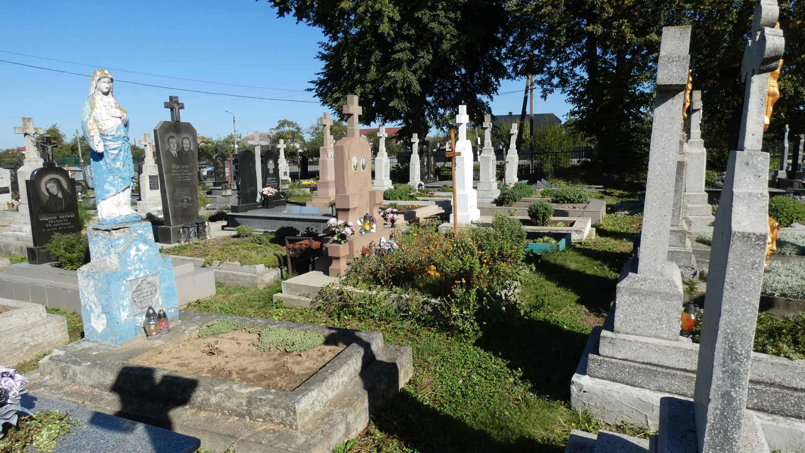 Вигляд українського цвинтаря з хрестами та меморіальними пам'ятниками у сонячний день.