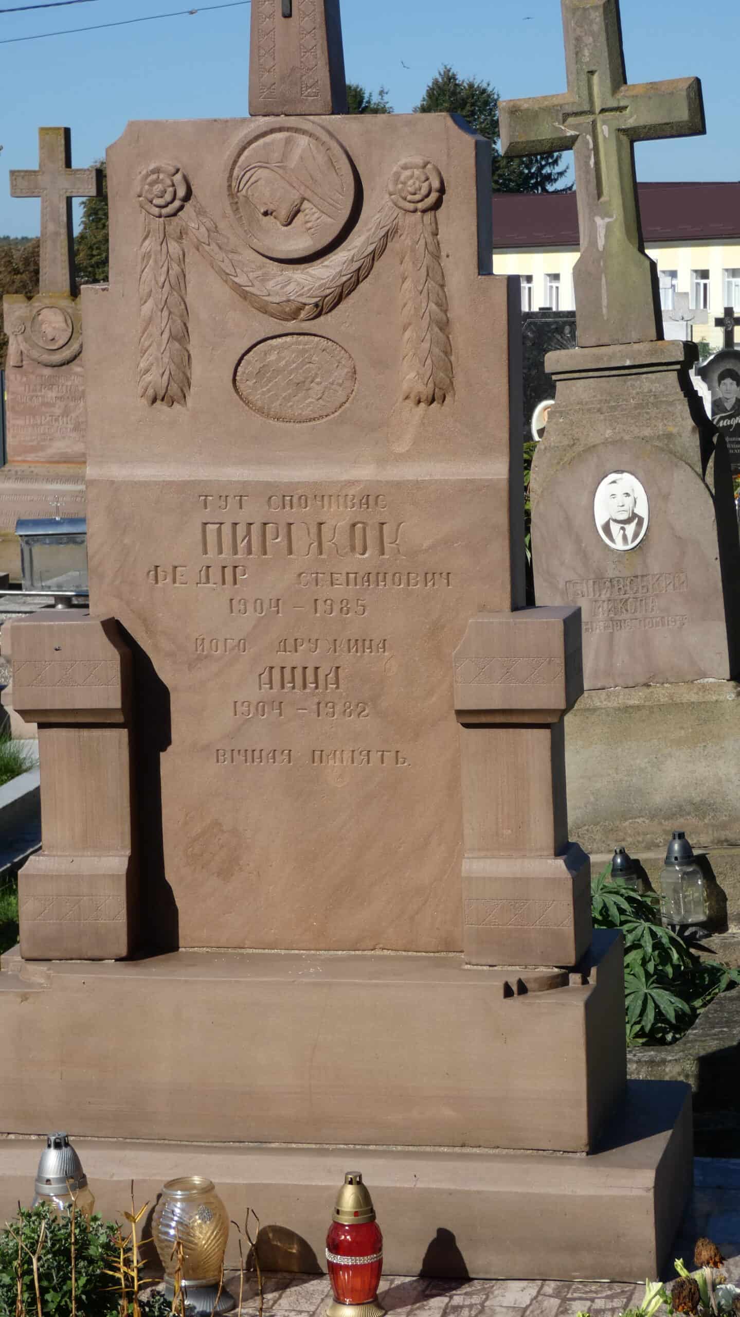 Могила на цвинтарі в Буцачі з написом про Федора Пиржока та його дружину Аню. Модель пам’ятника з символами та квітами.