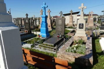 Могили на цвинтарі в Буцачі, Україна, з різноманітними пам'ятниками та квітами.