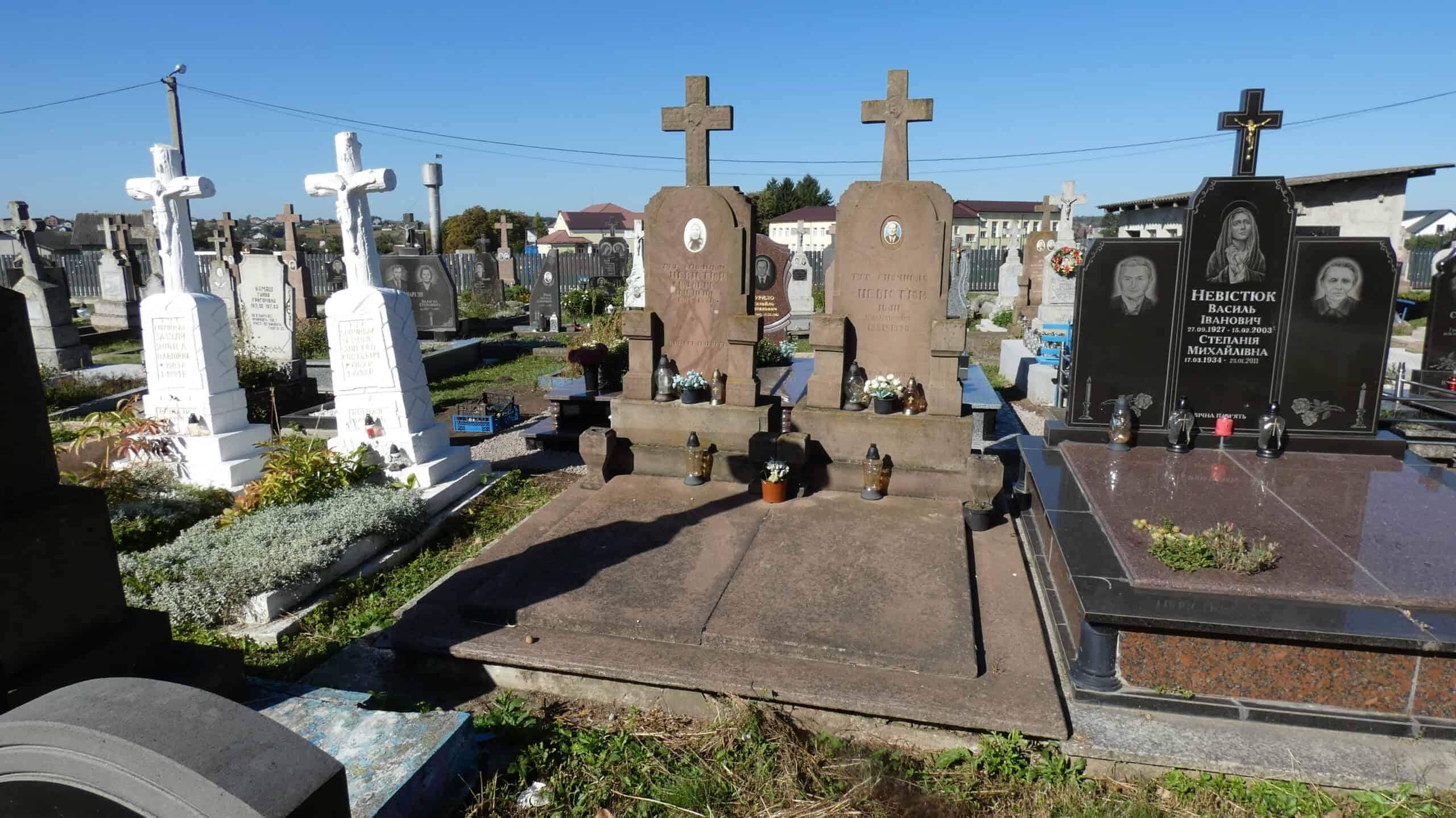 Вічний спочинок у Буцачському цвинтарі з пам'ятниками та квітами.
