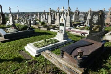 Меморіальні могили на цвинтарі в Буцачі, частина кладовища з пам'ятниками та квітами.