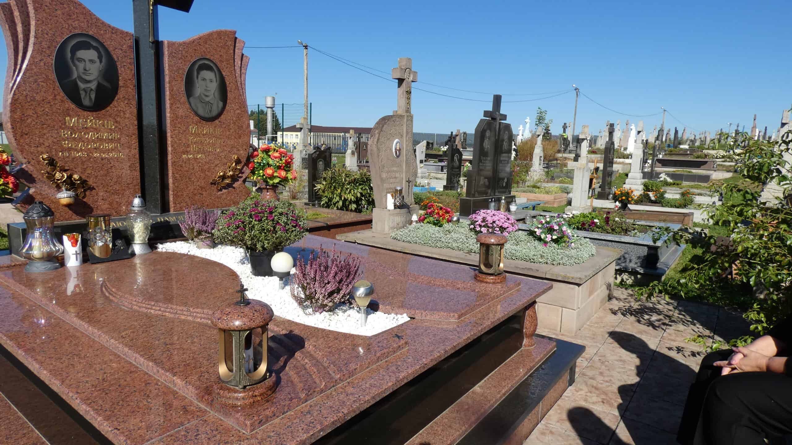 Вічний спомин на цвинтарі в Буцачі, пам'ятники з квітами та свічками, визначене місце поховання, меморіальні надгробки та пам'ять родини.