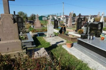 Могили на цвинтарі у Буцачі, поховання з пам’ятниками і квітами, історія та пам’ять у українському cemetery.