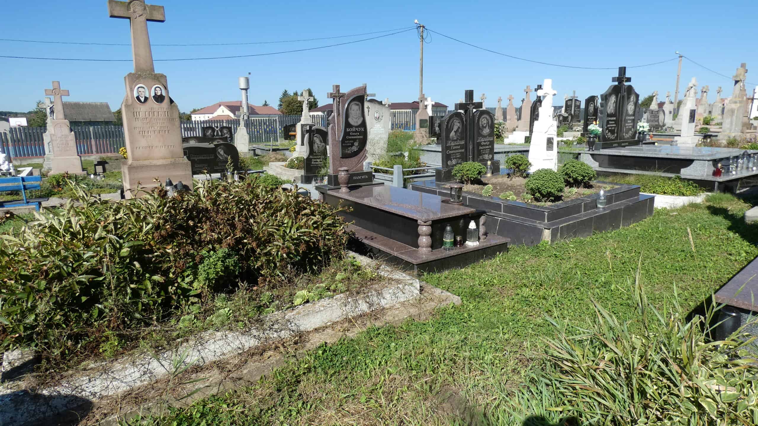 Вічні могили на цвинтарі Буцач, стильні пам'ятники, доглянуті зелень і квіти.