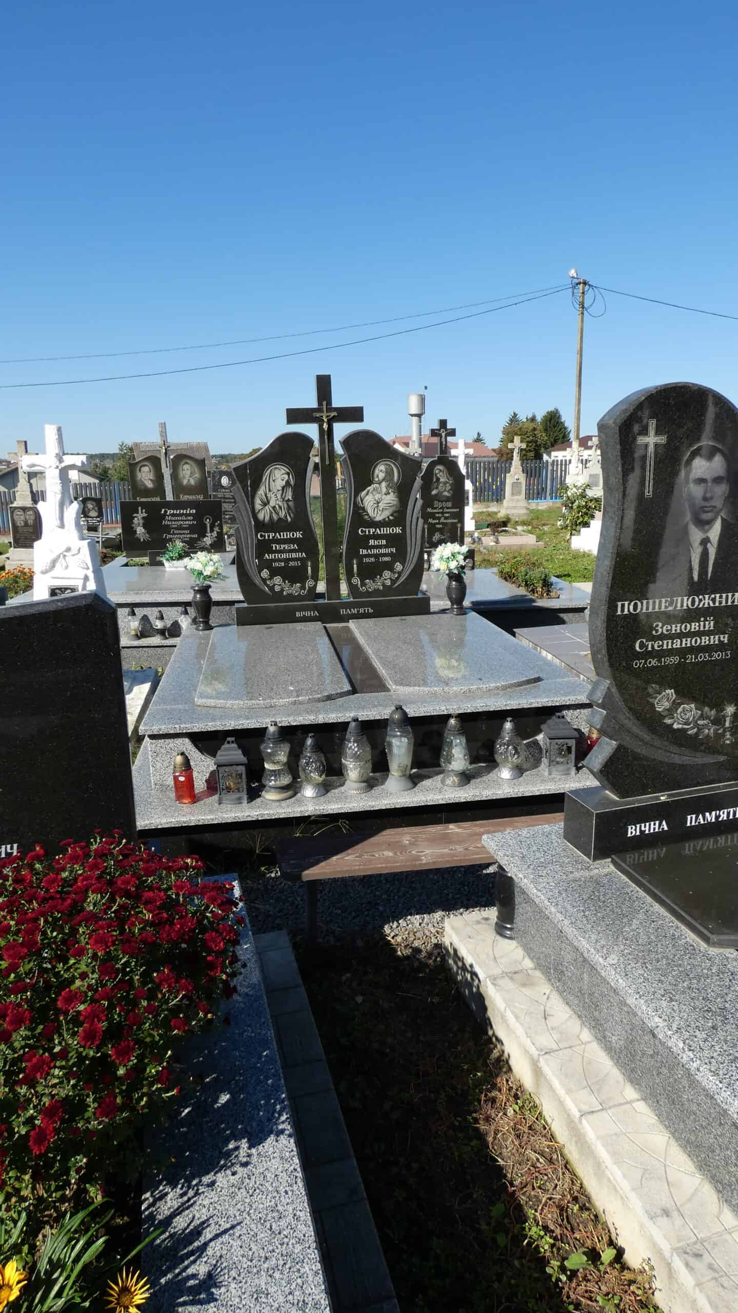 Могили на цвинтарі в Бучачі з пам’ятниками та квітами.