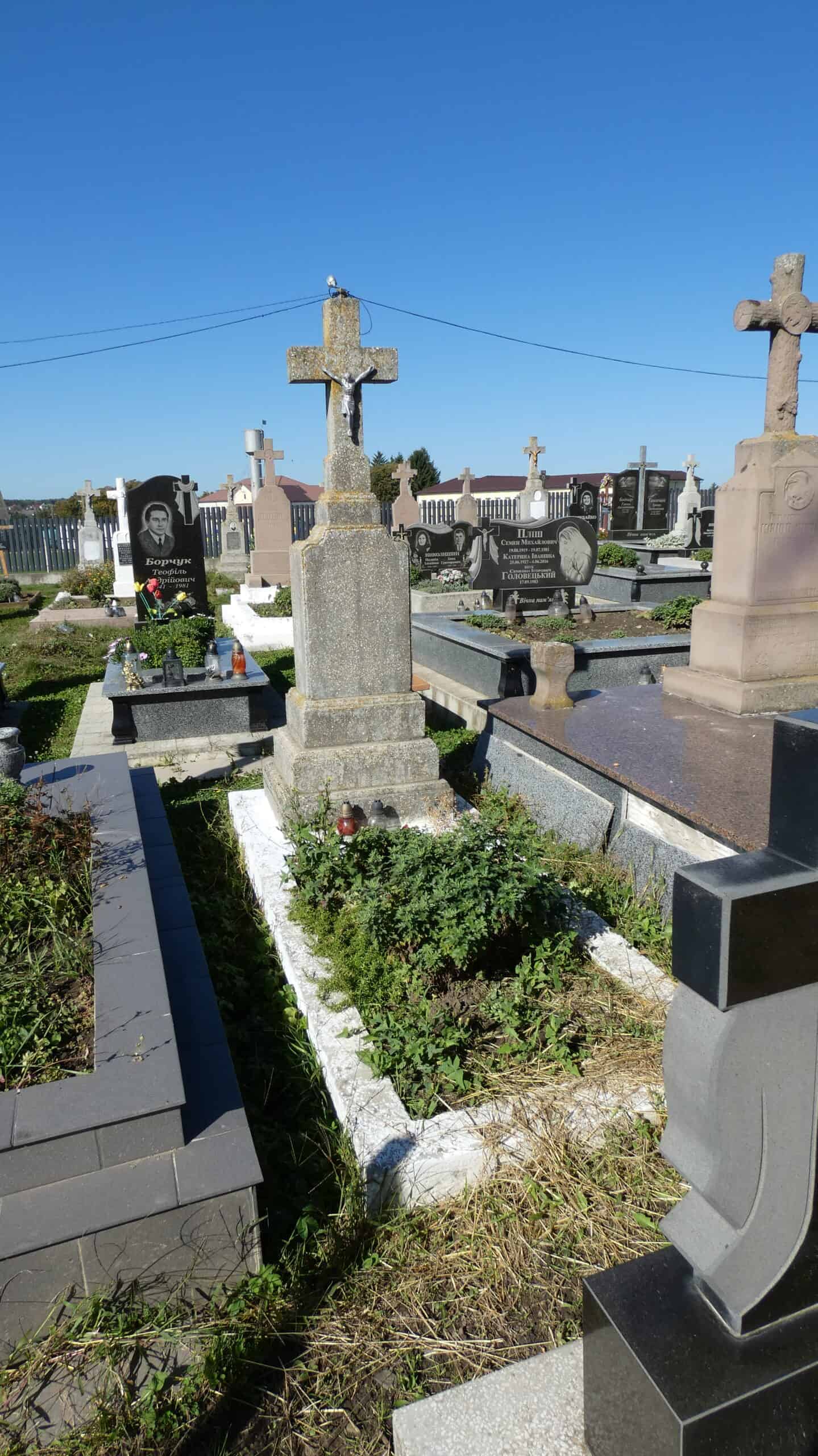 Кладовище у Буцачі, старий хрест на могилі, українські поховання, символ пам'яті та історії.