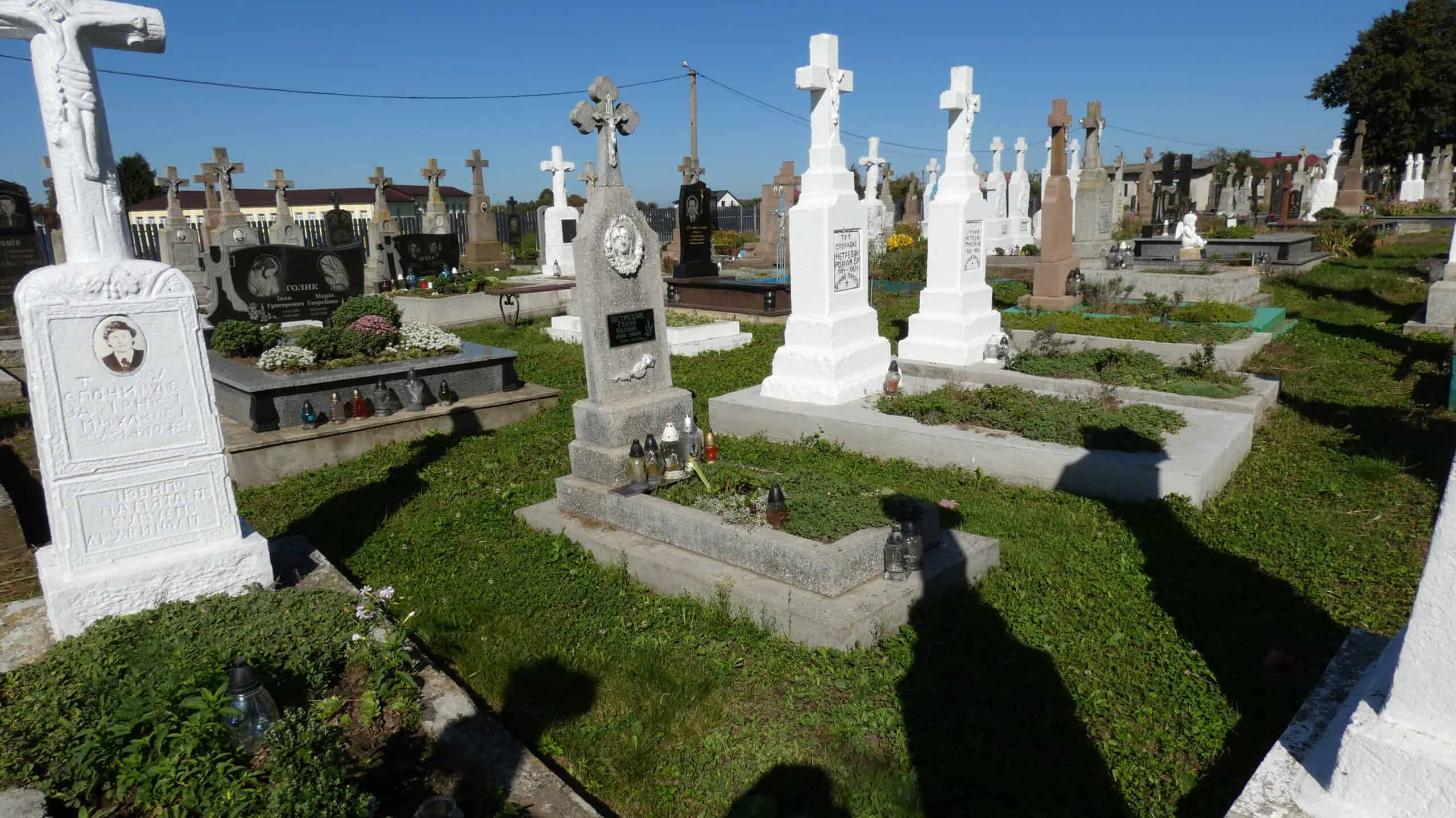 Могили на цвинтарі Бучач зростають у зелені, з безліччю пам’ятників та квітів.