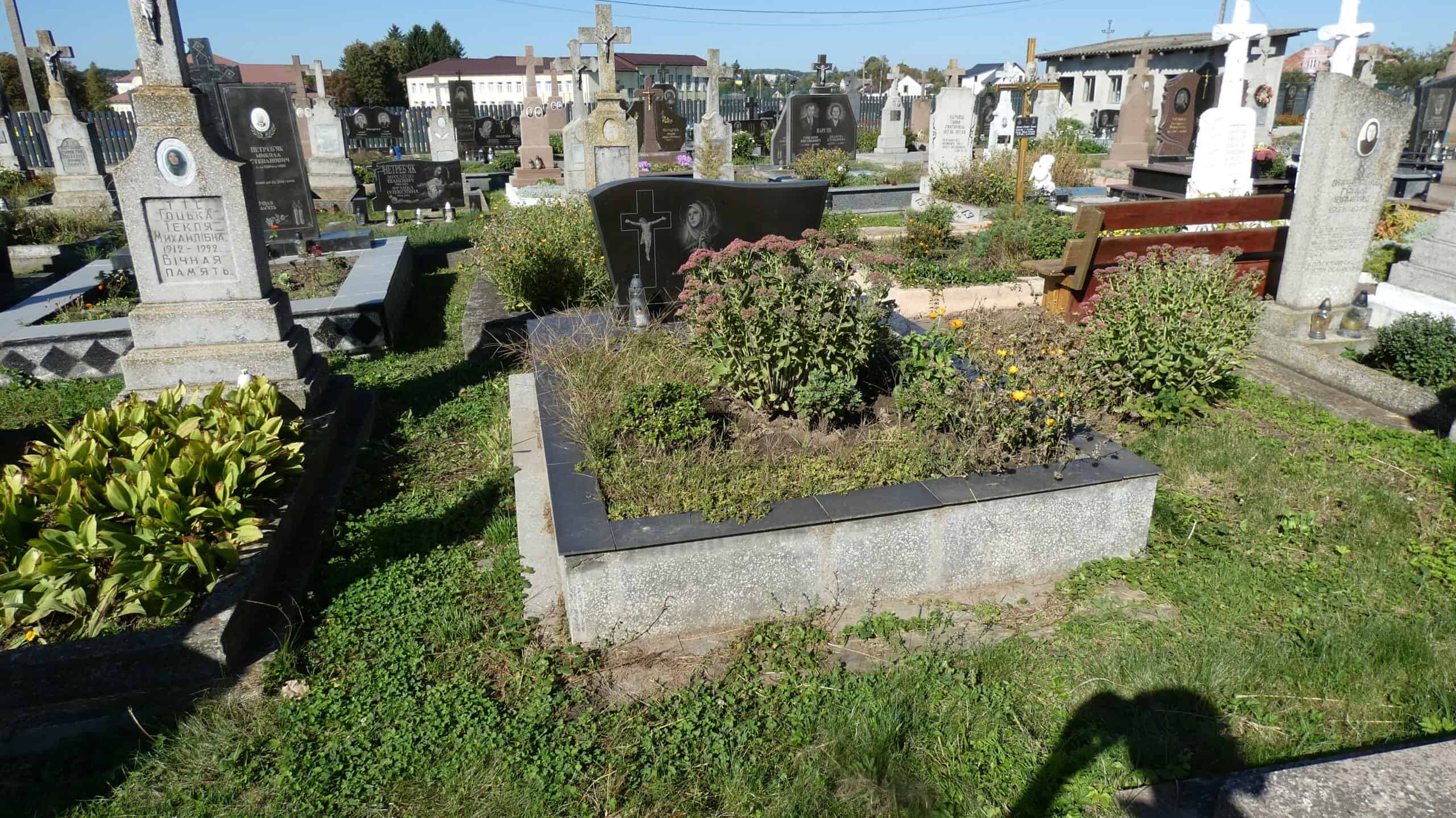 Меморіальний могильний пам’ятник з декоративними рослинами у цвинтарі Буцач, Україна.