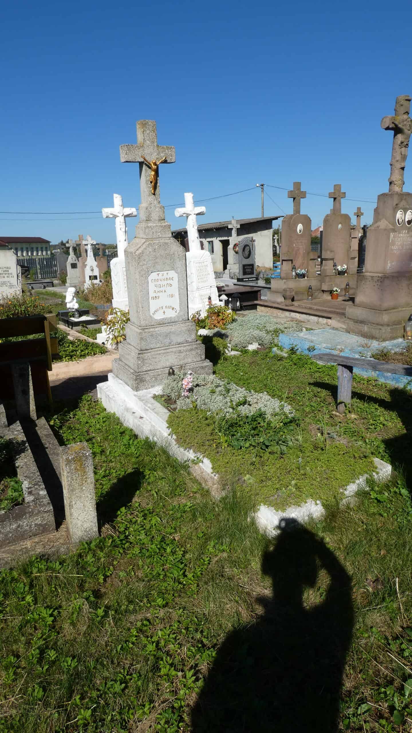 Вічний спочинок на цвинтарі Бучач, старі хрестові могили з квітами і зеленою травою.