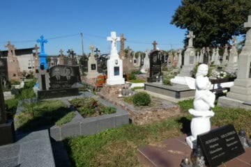 Могили на цвинтарі Буцак у Бучачі, Україна, з різноманітними пам’ятниками і квітами.