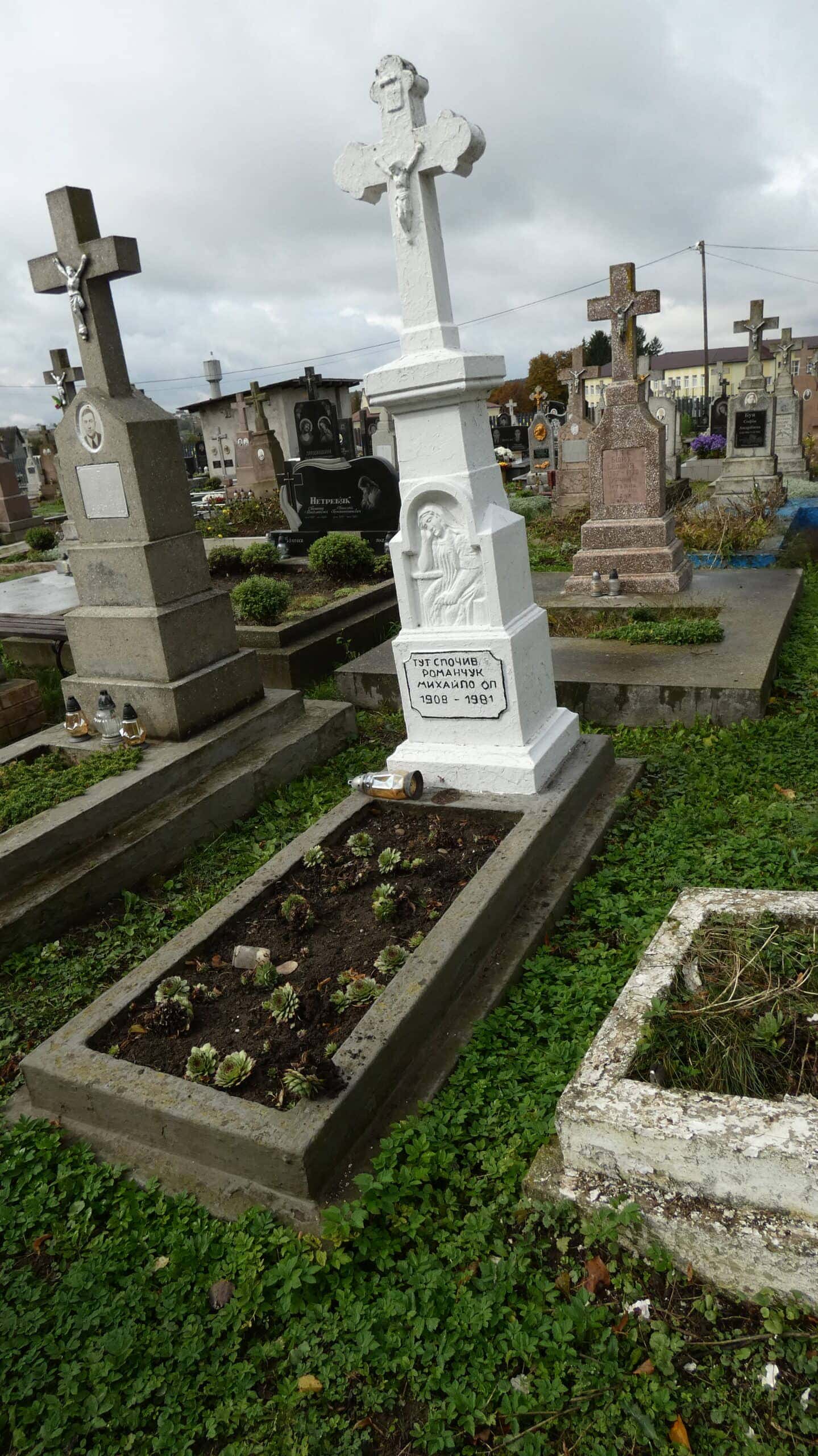 Могила на цвинтарі у Буцачах з хрестом і квітами.