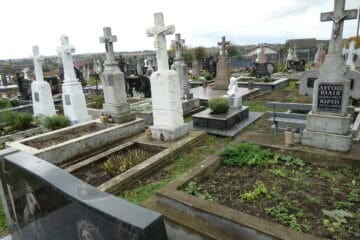 Могили на цвинтарі в Букачі, сімейні пам'ятники та хрести, меморіальні надгробки.