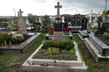 Могили на цвинтарі Буцаків, ухожені могили з квітами та фотографіями, красива панорама сільської місцевості.