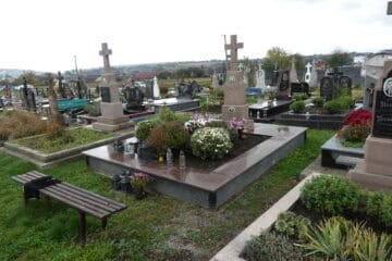 Могили на цвинтарі в Буцачі, український цвинтар з пам'ятниками та квітами.