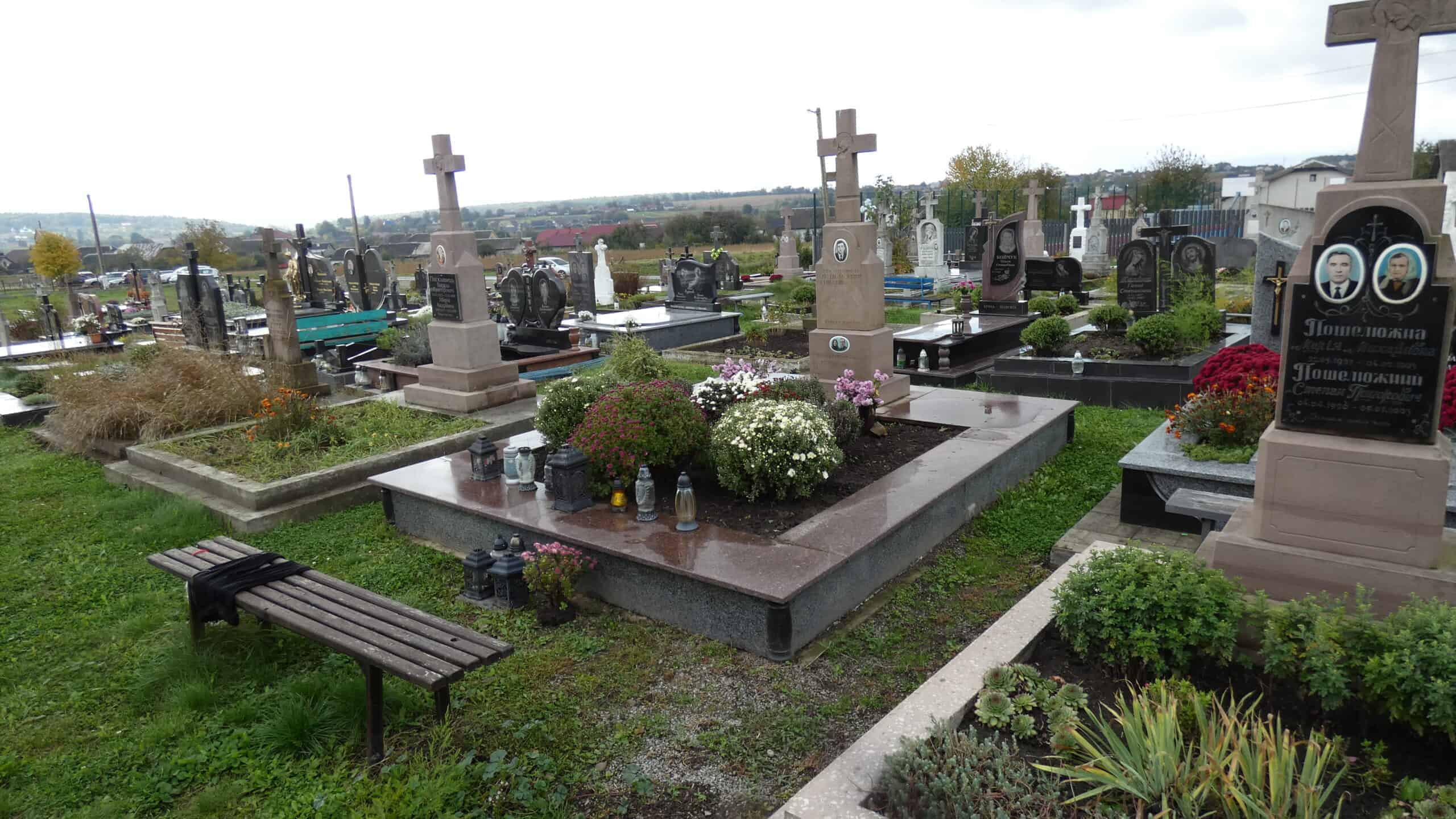 Могили на цвинтарі в Буцачі, український цвинтар з пам'ятниками та квітами.