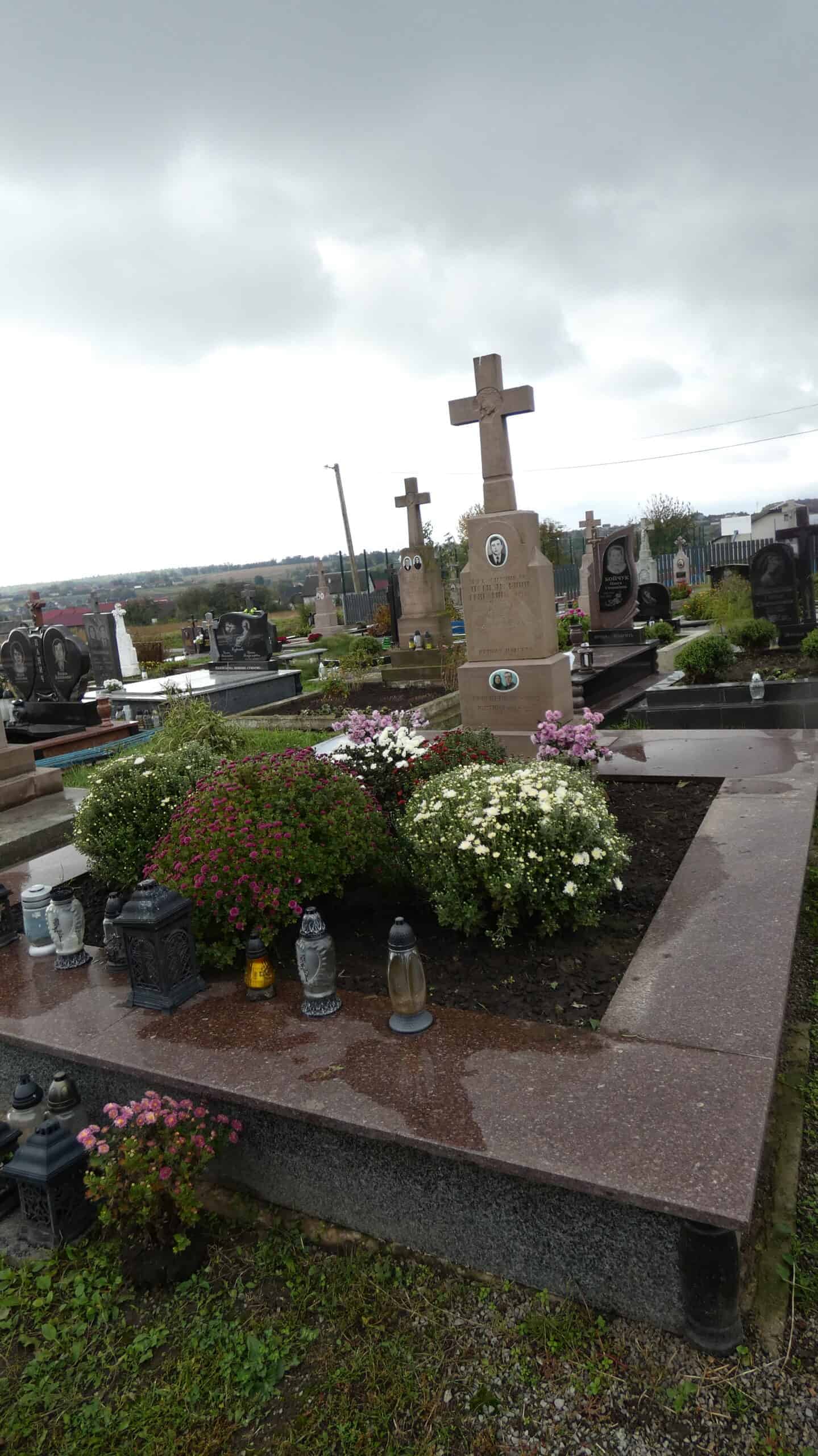 Могила з хрестами і квітами на цвинтарі Бучач. Поховання з пам'ятниками та квітковими композиціями.