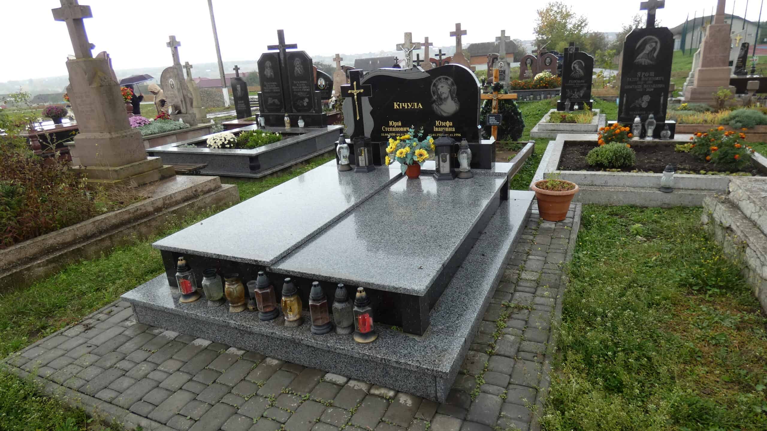 Охоронене могильне місце з пам’ятником та квітами на українському цвинтарі.