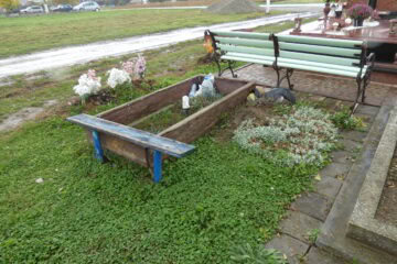 Могила на цвинтарі у Буцачі, квітучі рослини та меморіальні пам'ятки.