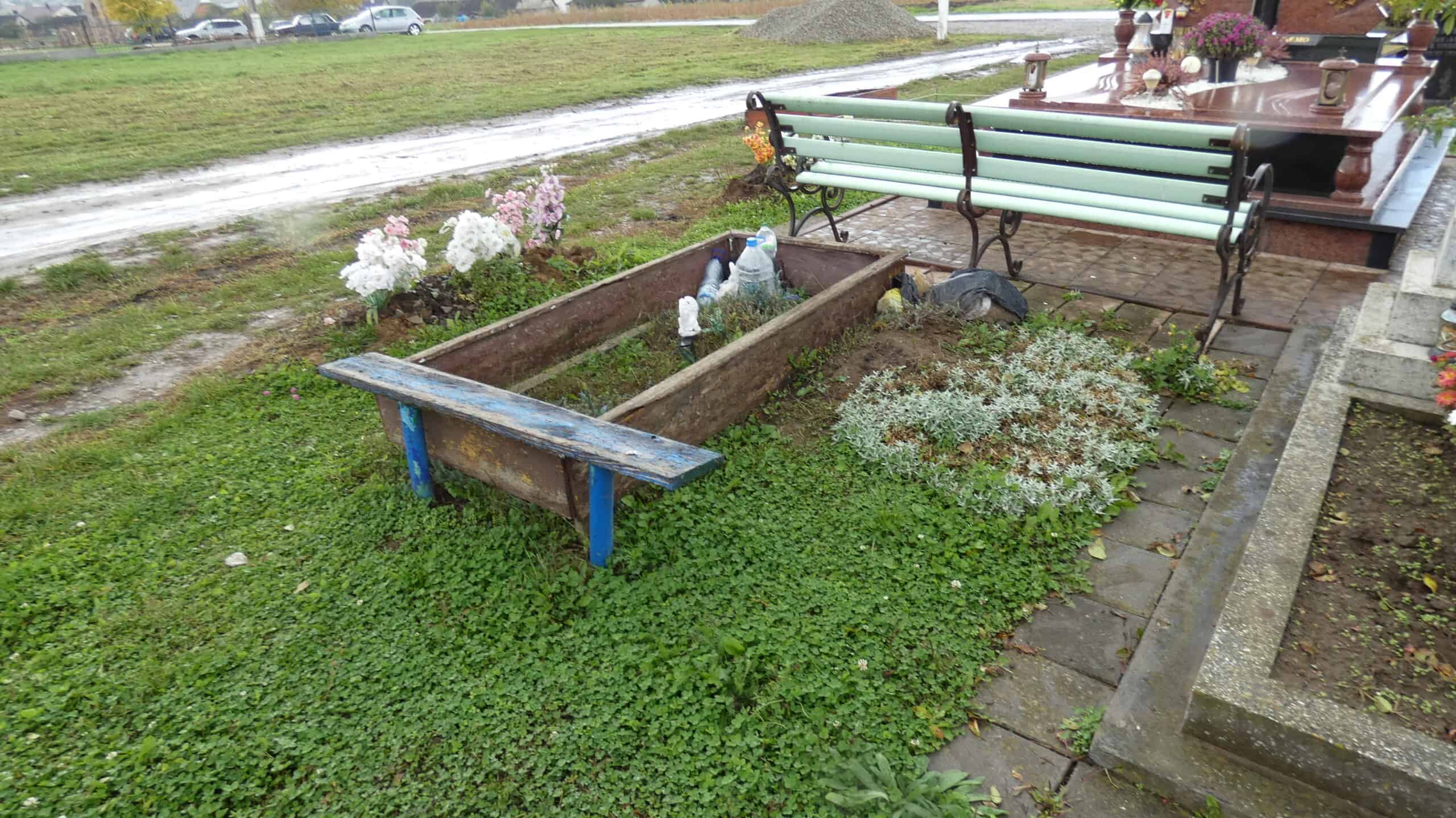 Могила на цвинтарі у Буцачі, квітучі рослини та меморіальні пам'ятки.