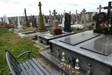 Меморіальні могили на цвинтарі в Буцазі з квітами та свічками.