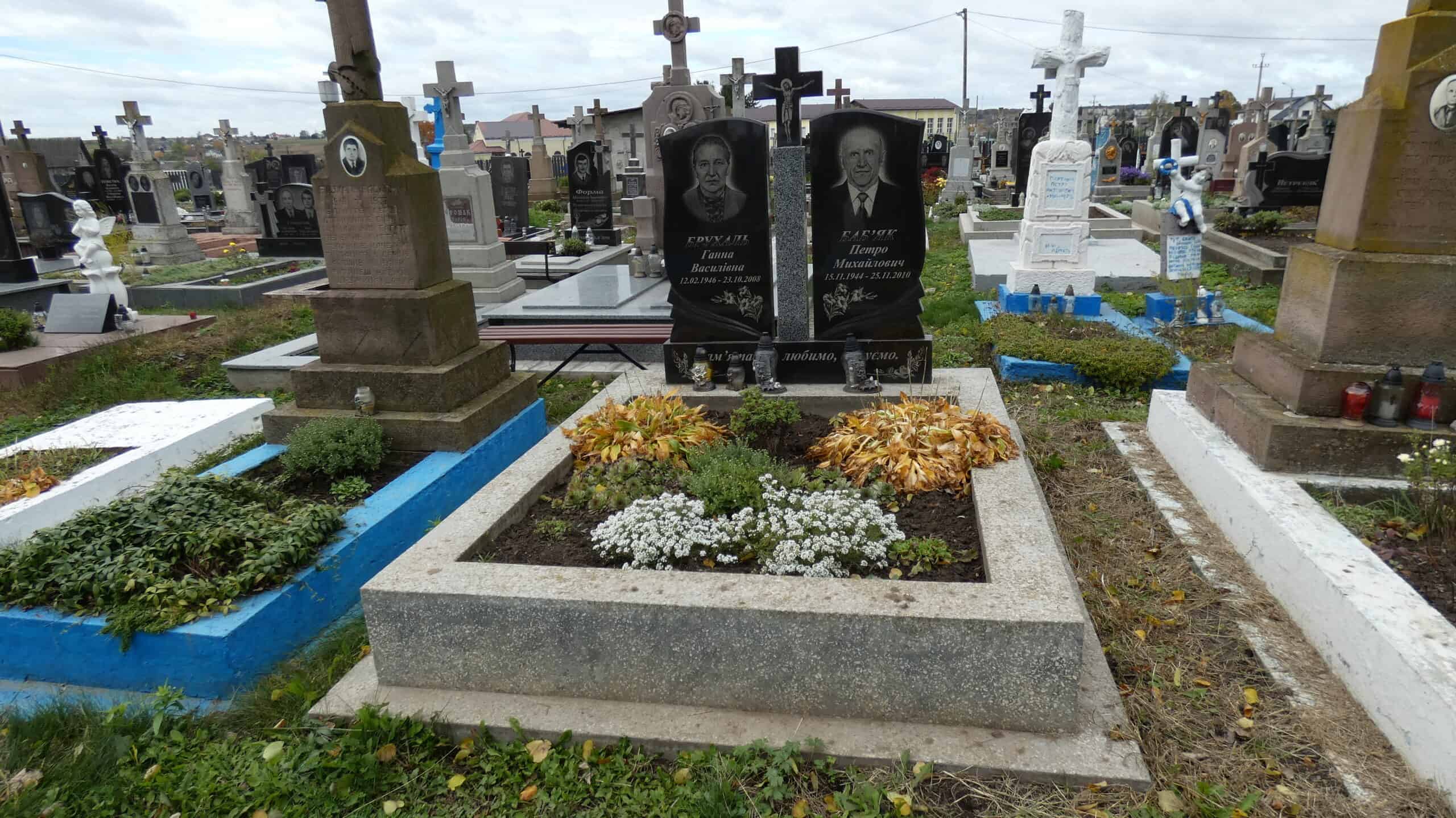 Вічний спочинок біля окутаних деревами та квітами могил на цвинтарі у Буцаче.