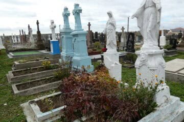 Могили на цвинтарі в Буцачі, хрестики та скульптури поховань, пам'ятники, меморіальні надгробки, засніжений поховальний комплекс.