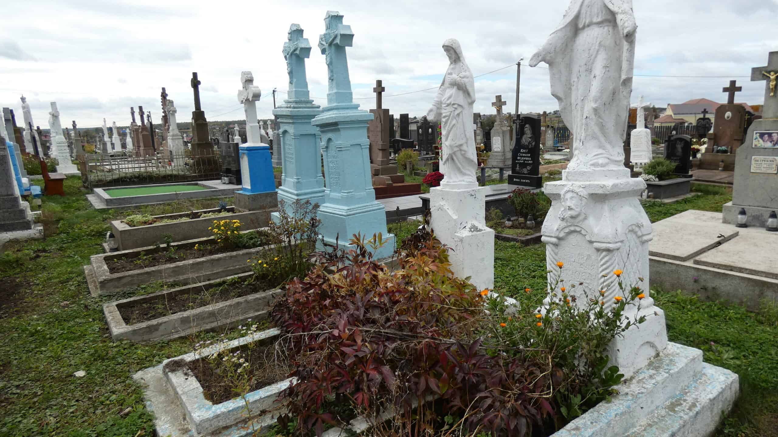 Могили на цвинтарі в Буцачі, хрестики та скульптури поховань, пам'ятники, меморіальні надгробки, засніжений поховальний комплекс.