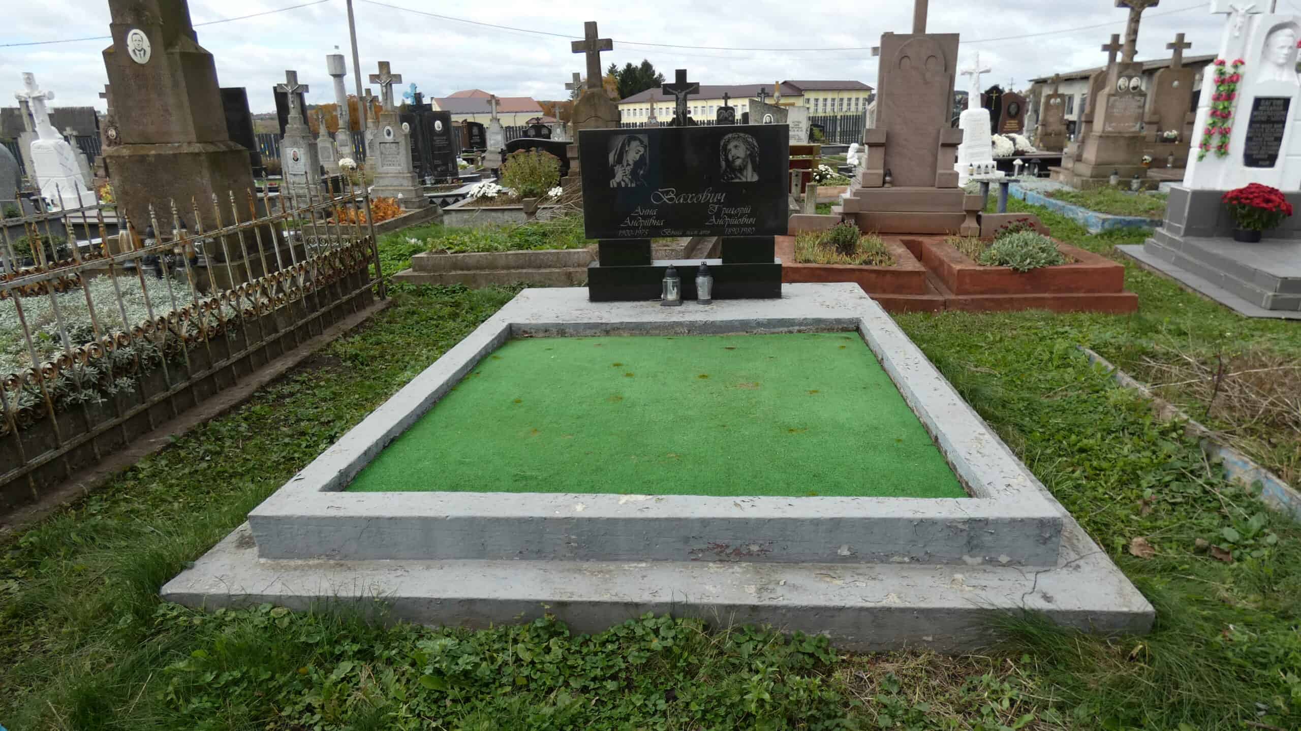 Могила з зеленим газоном, пам’ятник на цвинтарі Бучач, Україна.