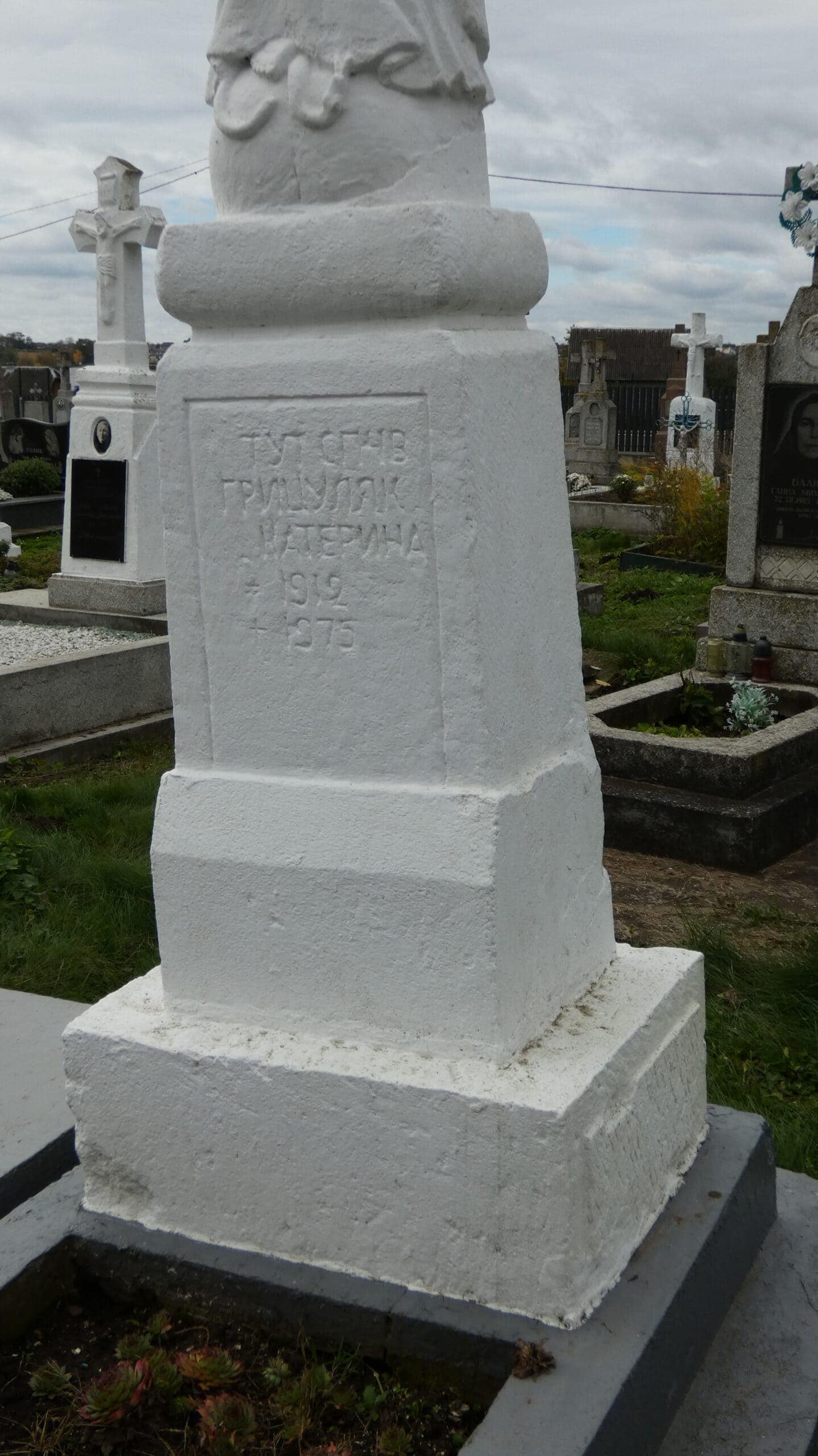 Вигляд білого пам’ятника на цвинтарі Буцаче з винесеною датою 1912 року.