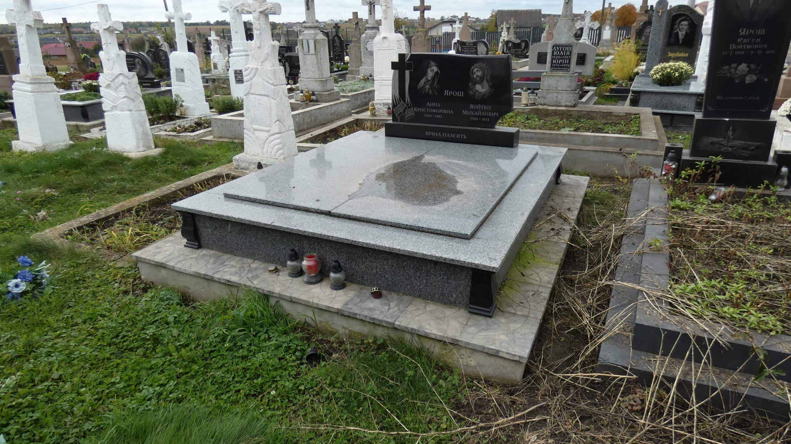 Вічний пам'ятник на цвинтарі в Буцачі. Виготовлений з гранітних матеріалів, з квітами та лампадками поруч.