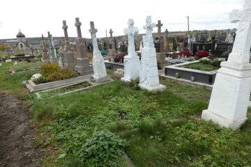 Могили на цвинтарі у Буцьачі з пам’ятниками та квітами, історичний цвинтар, український меморіал.