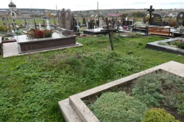 Кладовище з похилими могилами та квітковими оздобленнями в Буцязькому цвинтарі, територія з зеленню та деревами, українське поховальне кладовище.