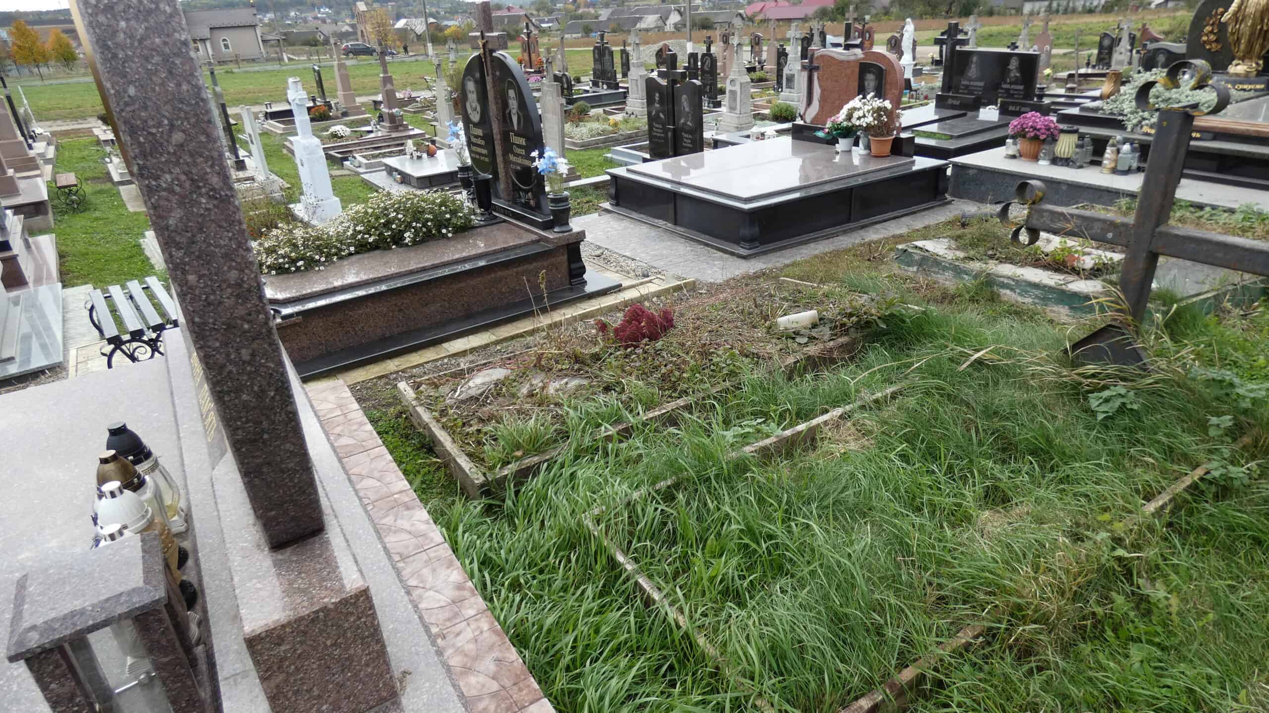Могили на цвинтарі Буцак, могили з сімейними меморіалами та квітами для поминання.