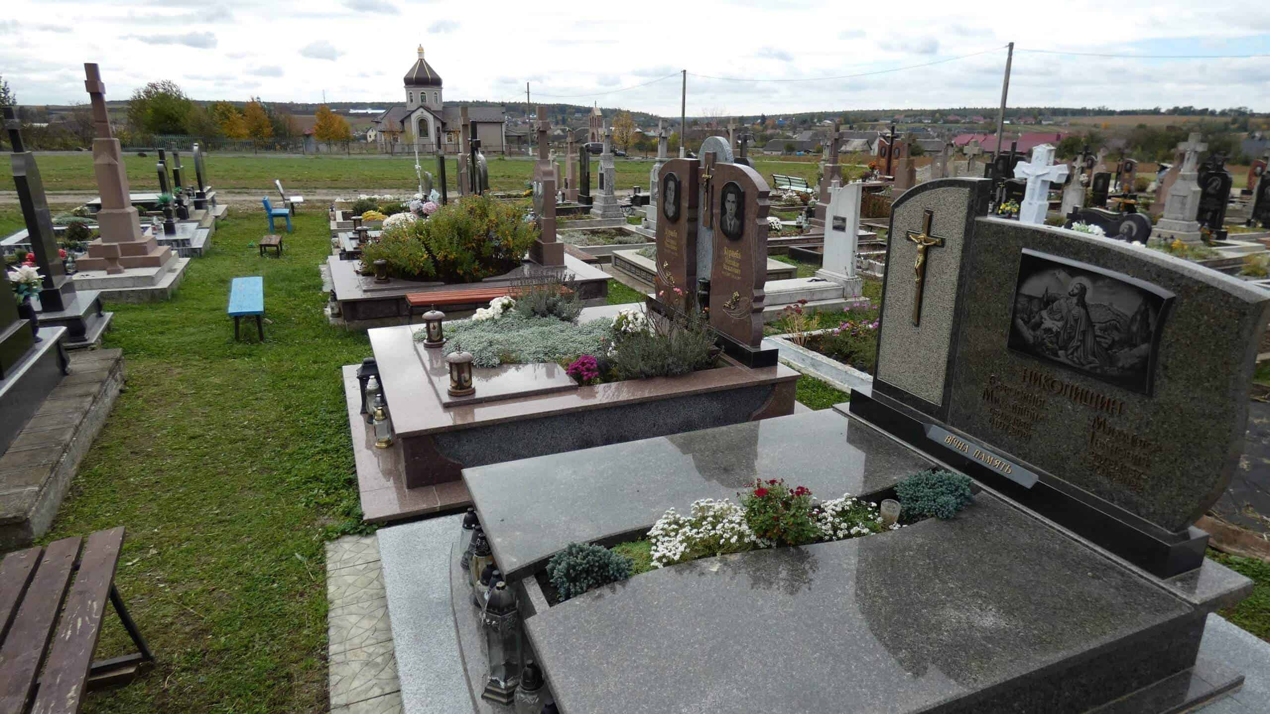 Могильні пам’ятники у цвинтарі Буцак, сучасний вигляд мальовничого кладовища, меморіальні надгробки та озеленення.